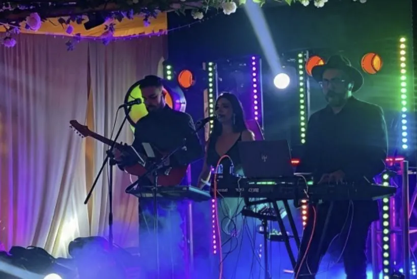 Banda en vivo crossover de 3 músicos tocando con luces en una fiesta