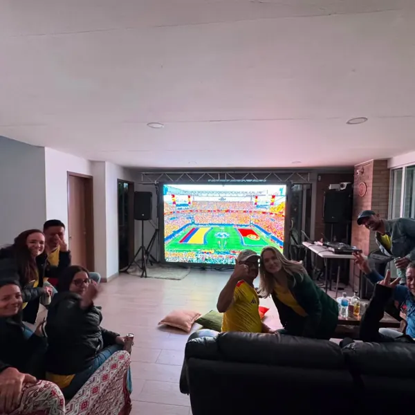 Invitados viendo el Mundial en pantalla LED durante una fiesta en casa