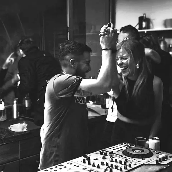 Pareja bailando junto a la cabina del DJ en una fiesta en casa