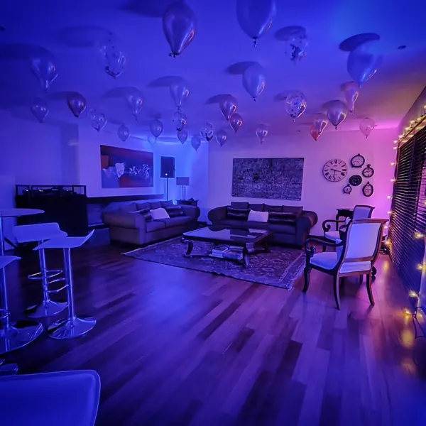 Sala de una casa ambientada con luces LED y globos antes de la fiesta