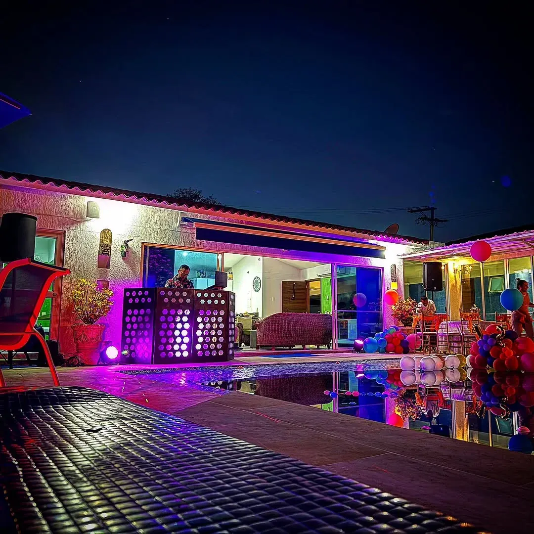 Setup de DJ con luces en la terraza de una casa campestre de noche