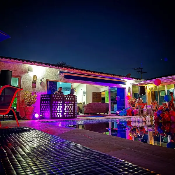 Setup de DJ con luces en la terraza de una casa campestre de noche
